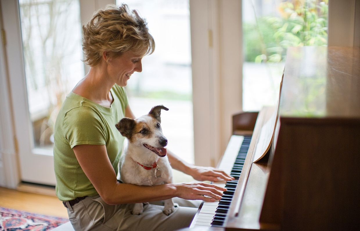 žena se psem hrající na piano